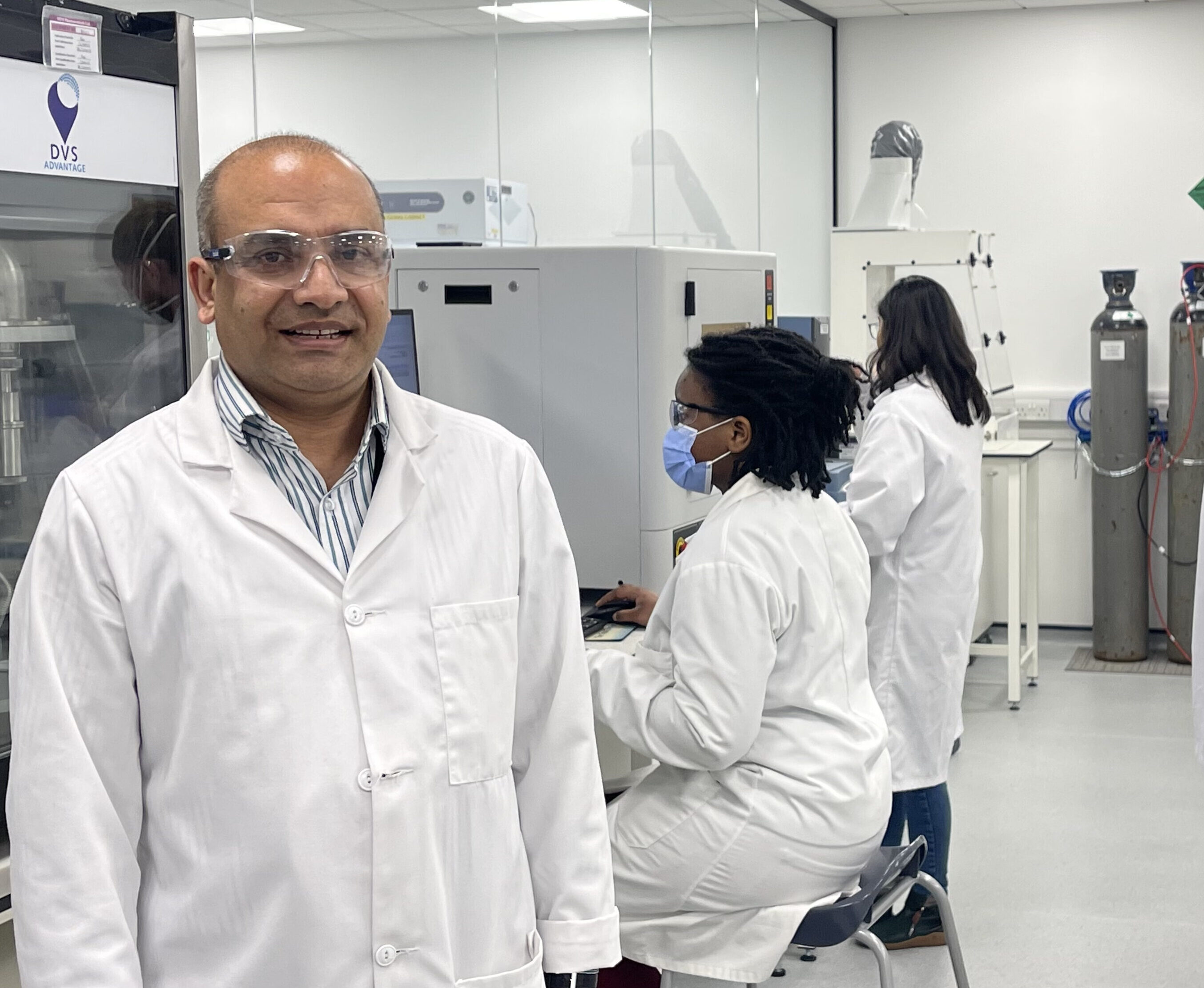 A group of men in lab coats standing in a lab.