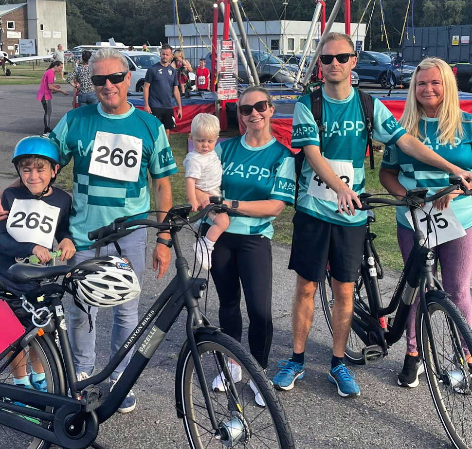 A group of people posing for a photo with their bicycles.